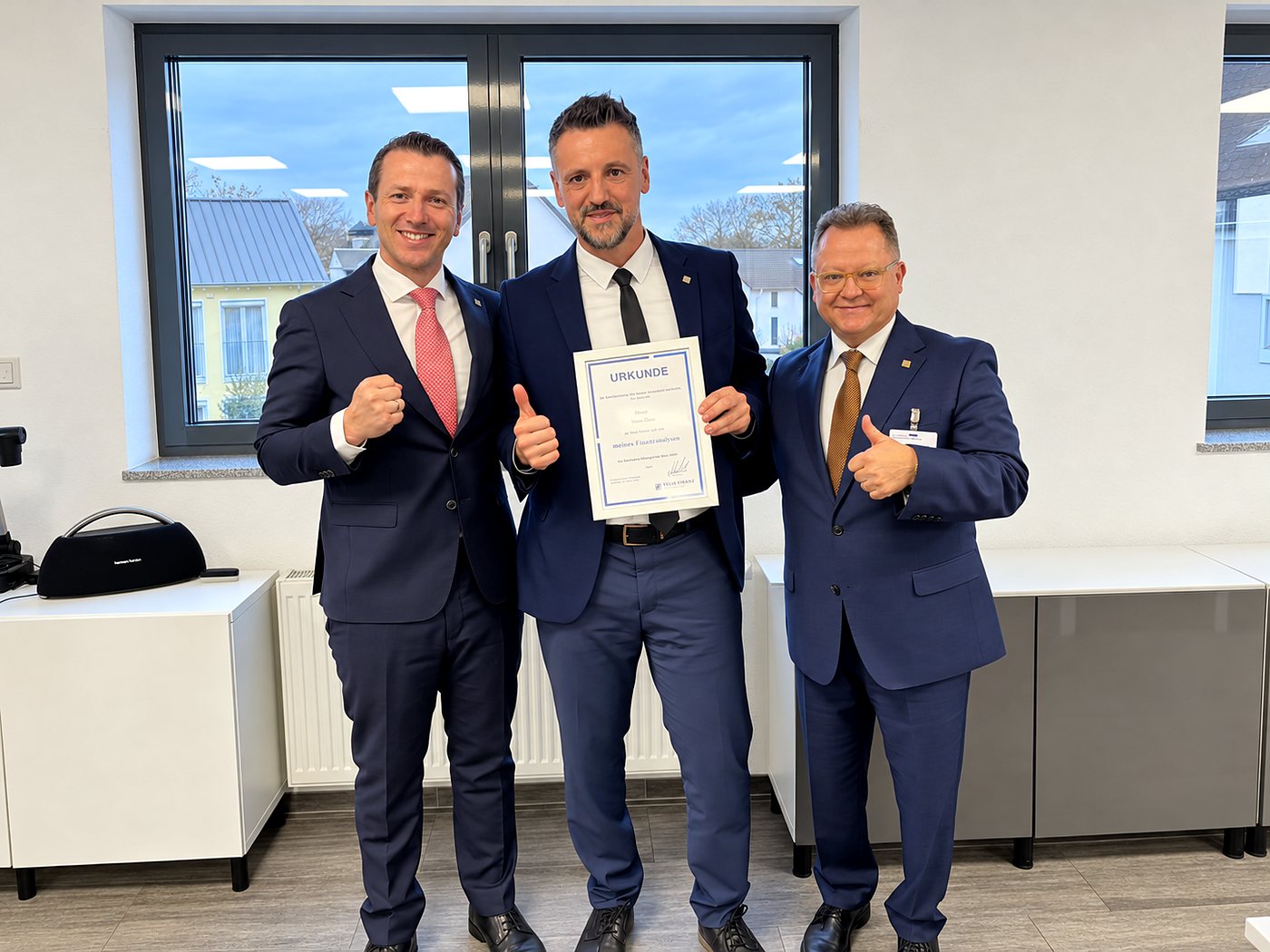 Ihr Berater mit zwei Kollegen von TELIS FINANZ bei der Übergabe einer Urkunde